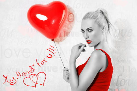 sexy blonde girl with heart shaped balloon, she is turned at right, blck and white image with color red t-shirt . valentines day conceptの写真素材