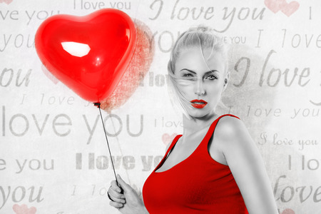 sexy blonde girl with heart shaped balloon, she looks in to the lens with sensual axpression and has hair on the face, black and white image , with some part in red. valentines day conceptの写真素材