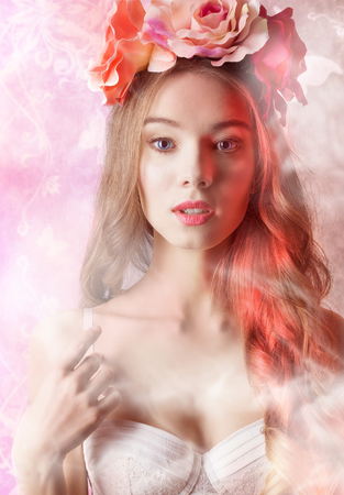 Beautiful, romantic, retro woman in white bra and flowers on head, she has got curly, long hair and natural make up.Filtered imageの写真素材