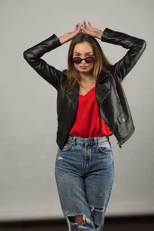 cute brunette in casual dress, jeans and jacket taking pose on white and looking in cameraの写真素材