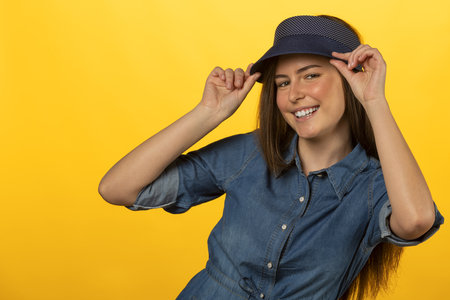 beautiful young woman in jeans looking in camera smiling she hae a summer blue capの写真素材