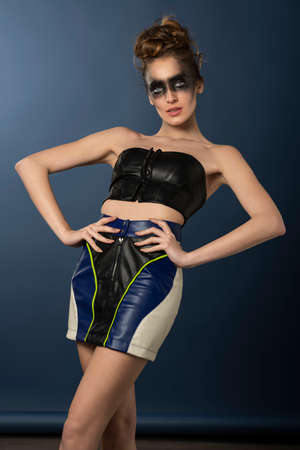 sexy model dressin a striped colored gown and black top, fitting close outfit, with dark creative make up on face in punk style, she has hairstyleの写真素材