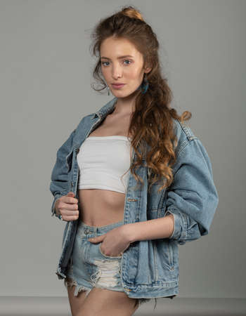 pretty woman in outfit dress, she is posing and looking in camera with shorts and jacket jeansの写真素材