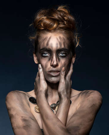 beautiful young woman with fashion dirty make-up she posing over dark blue with hairstyle. caucasian girl. recycled conceptの写真素材