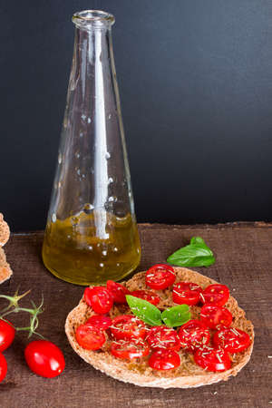 Freselle with tomatoes photographed on a wooden base