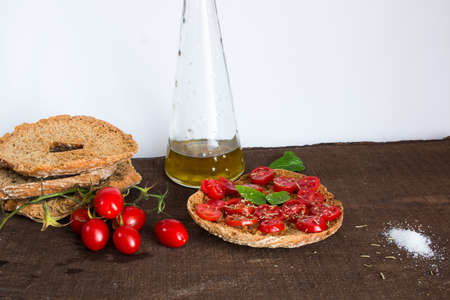 Freselle with tomatoes photographed on a wooden baseの写真素材