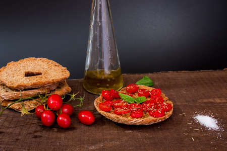 Freselle with tomatoes photographed on a wooden baseの写真素材
