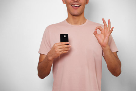 young man smiling with happiness when having a new credit card