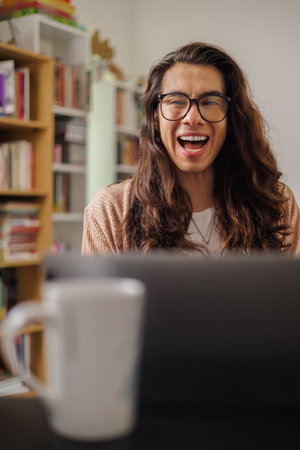 Person with glasses working from home with a big smileの写真素材