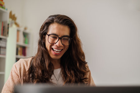 Person with glasses working from home with a big smile