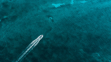 Aerial view of a boat sailing the beautiful crystal-clear blue waters of Cancun, Mexico, Riviera Mayaの写真素材