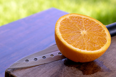 Sliced orange on a cutting board with a kitchen knife.の写真素材