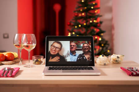 Laptop on the christmas table. Video call with the family in times of coronavirus.の写真素材