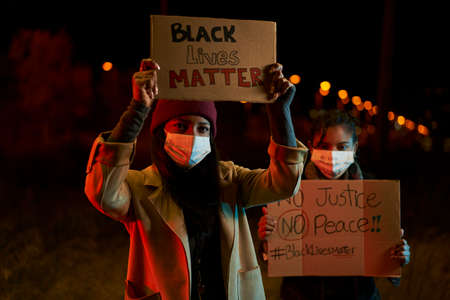 African American women demonstrating against racism. Demonstrators in a city with banners fighting...