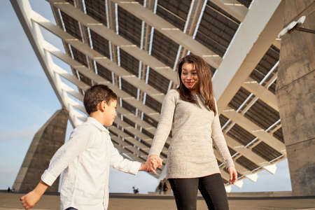 Young single mother taking a sunset walk with her son. Single parent Latino family.の写真素材
