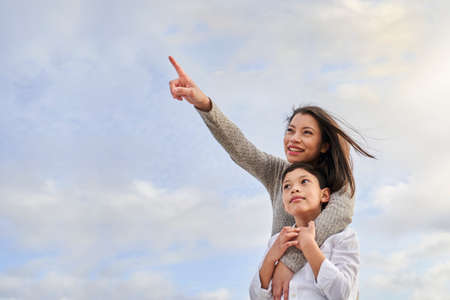 Young Latina mother with child pointing to some point. Family concept.の写真素材