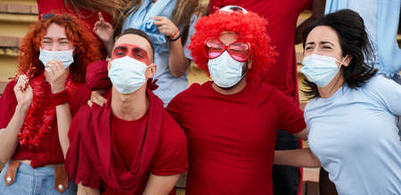 Panoramic photo of a group of people of different races follow the soccer match in the stands...