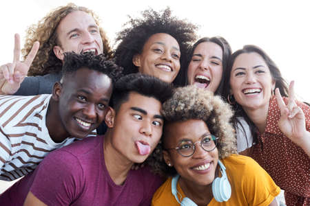 Portrait of friends take a picture with a mobile phone. Multiethnic concept, selfie, friendship, play the fool.の写真素材