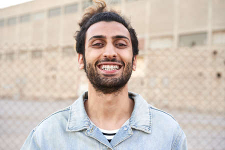Cute brunette man laughing in the street.