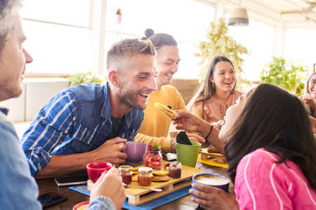 Group of Happy friends having breakfast in the restaurantの写真素材
