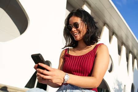Woman Smiling and Using Mobile Phone Outdoors. Happy People smartphone.
