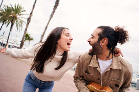 Happy couple having fun singing and dancing outdoorsの写真素材