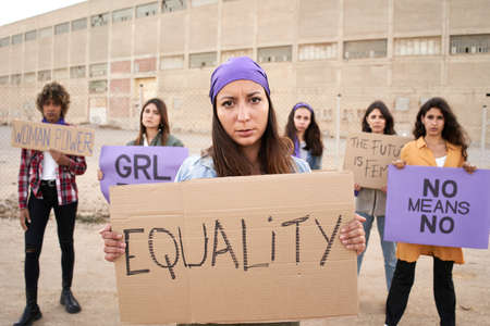 Feminist with a banner at a protest. Women activist demonstration.の写真素材