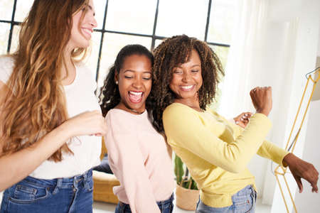 Party at home Diverse female friends dancing living room indoors. Multiracial happy women play and celebrate the joy of life Cheerful girls enjoy together having fun.の写真素材
