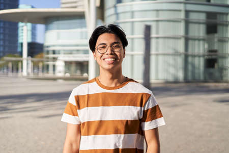 Happy asian Student. Guy smiling at camera outdoors on campus of universityの写真素材