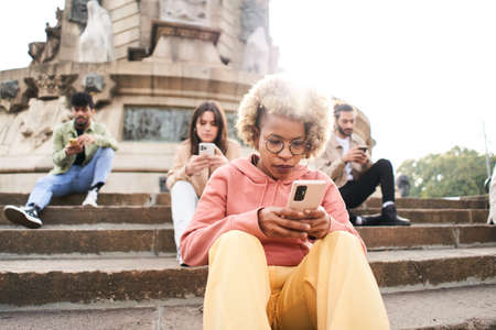 Group of people using phone with serious face and ignoring each other. A woman focused on their...