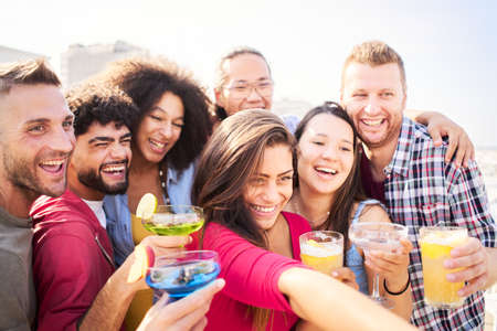 Happy group of friends taking selfie drinking beer at brewery terrace bar. Friendship concept on young people enjoying time together and having fun.の写真素材