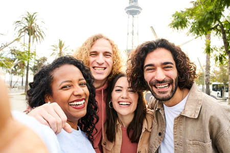 Selfie of Multi-ethnic group of smiling people looking at the camera. Cheerful photo of happy friends having fun togethersの写真素材
