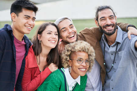 Group of young people standing outdoors, making a selfieの写真素材