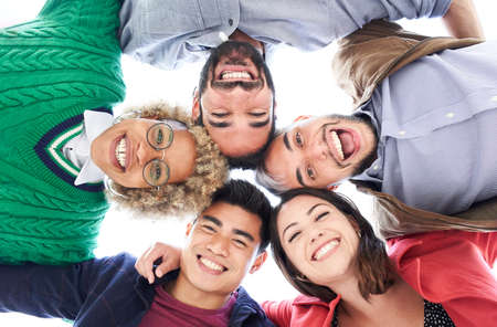 Multiracial group of friends having fun. Group of people standing in circle smiling looking at the camera and laughing. Concept of friendship.の写真素材