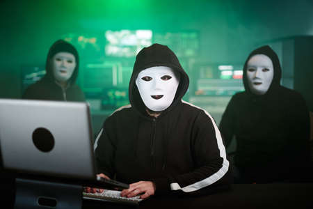 Masked Hacker is Using Computer for Organizing Massive Data Breach Attack on Corporate Servers....