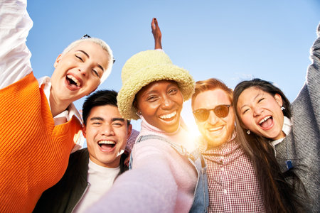 Smiling selfie of a happy group of multicultural friends looking at the camera. Portrait of cheerful multi-ethnic young people of diverse races having fun together. Community and friendshipの写真素材