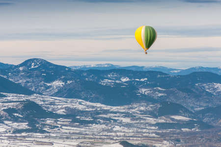 Balloon flying over snowy mountainsの写真素材