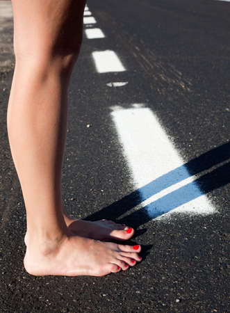 Barefoot woman in a roadの写真素材