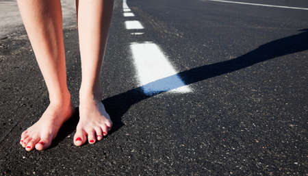 Barefoot girl on the roadの写真素材