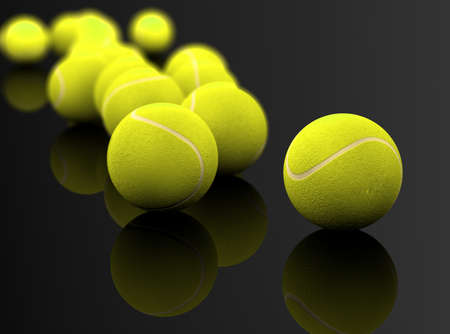 3d image of several tennis ball isolated in black backgroundの写真素材