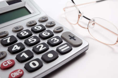 Business background with calculator and glasses isolated in whiteの写真素材