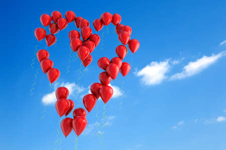 Balloons floating in the sky with heart shapeの写真素材