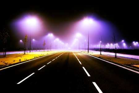 Road and city lights. Foggy cityscape and lampost
