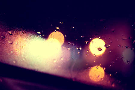 Wet window background and city lights.Rainny night through the glass
