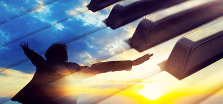 Piano keys abstract background and man with open arms. Relax music for travel road.の写真素材