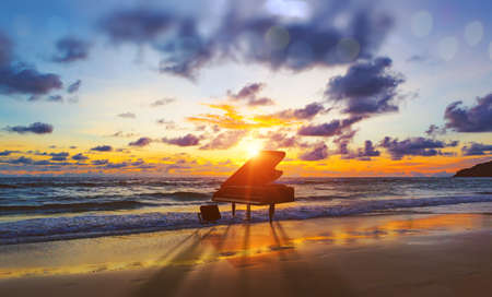Surreal image of grand piano in scenic sunset beachの写真素材