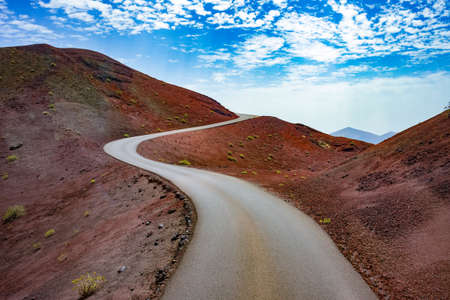 Road through the scenic landscape to the destination in Timanfaya natural park in Lanzarote,Canary island,Spainの写真素材