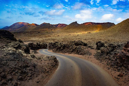 Road through the scenic landscape to the destination in Timanfaya natural park in Lanzarote,Canary island,Spainの写真素材