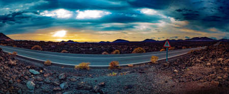 Road through the scenic landscape to the destination in Timanfaya natural park in Lanzarote,Canary island,Spainの写真素材
