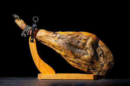 whole dry Spanish ham isolated on black background.の写真素材
